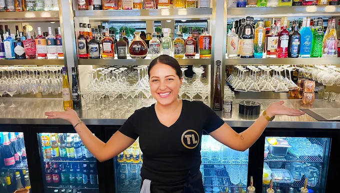 A bartender smiling behind the bar