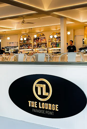 The bright, airy interior of The Lounge, looking toward the bar and the illuminated Paradise Point sign